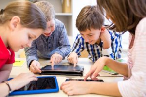 Group of children playing on iPads